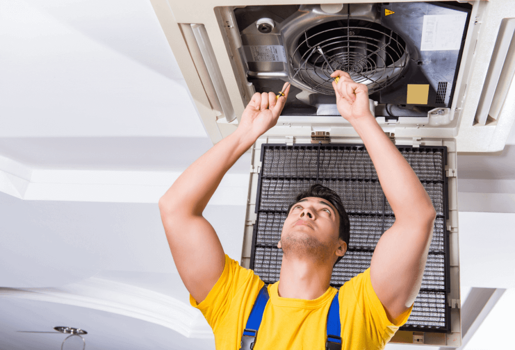 A picture of an HVAC expert fixing an A/C unit.